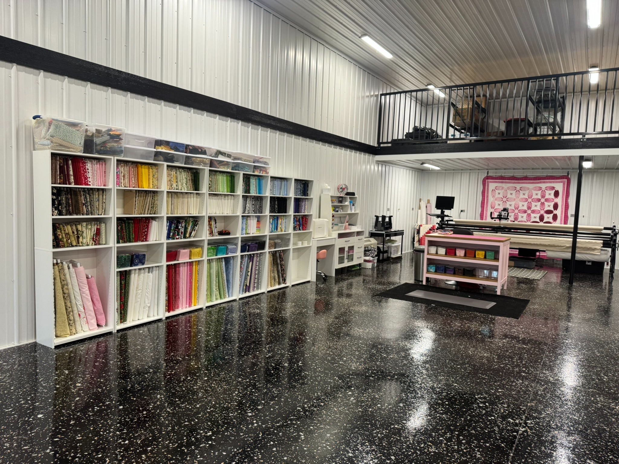 Tina’s sewing studio with colorful fabric shelves and Dolly’s longarm frame